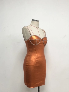 Detailansicht des orangen Metallic-Kleids mit Strasssteinen an Cups und Trägern am Mannequin