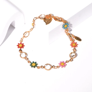 Detailed macro of gold chain bracelet with colorful enamel flowers and shining rhinestones