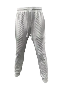 Detailed view of white textured knit joggers with a geometric diamond pattern and drawstring