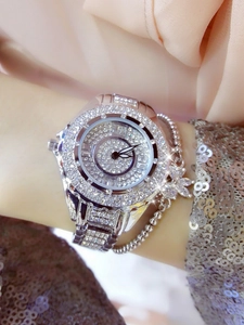 Macro shot of silver crystal-encrusted watch on wrist with shimmering stones and metal band