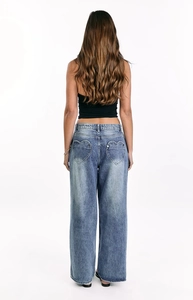 Detail of heart-shaped back pocket stitching on vintage wash wide-leg denim jeans