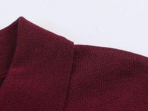 Détail du polo en maille bordeaux montrant le col et la texture des coutures