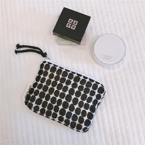 Close-up of a small canvas pouch with black gingham pattern and a simple wish label