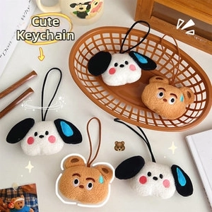 Detail of cute plush cartoon puppy and bear charms with soft embroidery on a cozy desk