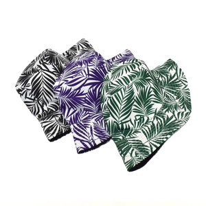 Detailed view of bucket hats featuring tropical palm leaf prints in black, purple, and green