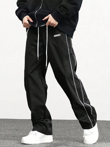 Detail of loose fit jogger pants featuring elastic waist with contrast white drawstring