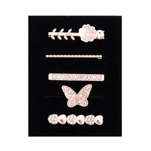 Detail view of 5-piece rose gold hair clip set with rhinestones on a black background