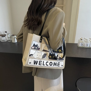 Minimalist beige canvas tote bag with cute cartoon cat print and Welcome text