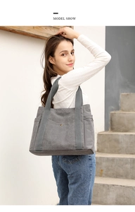 Close-up of grey canvas tote bag showing side pocket and durable fabric straps