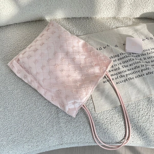 Détail du sac cabas en satin rose avec broderie d'étoiles et fermeture par cordon