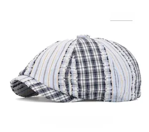 Detail shot of distressed cotton newsboy cap with vintage patchwork pattern and frayed edges