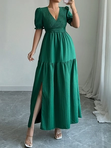 Détail de la robe verte à col en V avec texture plissée et fente latérale élégante