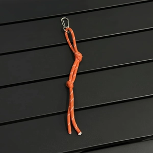 Detailed view of orange braided rope keychain with reflective thread and metal carabiner