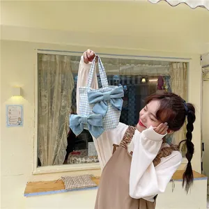 Detail of blue plaid canvas tote bag with 3D denim bows and sturdy top handle