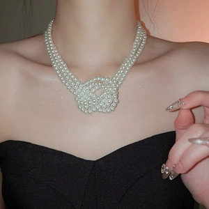 Detail of French three-layer knotted pearl necklace worn by a model for elegant look