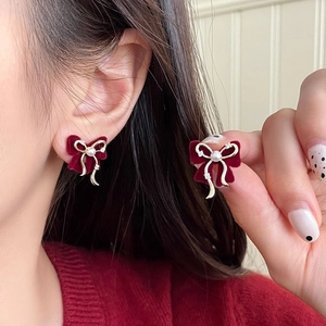 Détail du nœud en velours rouge plaqué or 14 carats avec perle et petits strass
