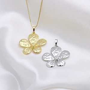 Elegant gold and silver five-petal flower necklaces on white silk background