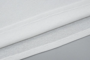 Détail du tissu en maille côtelée blanche et des coutures précises de la robe moulante