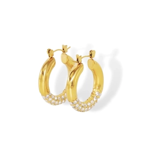 Detail of gold-plated hoop earrings featuring micro-pave sparkling crystals on white background