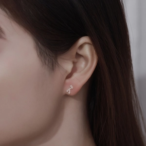Macro shot of 999 silver bear stud earring featuring full pave zircon inlay on ear