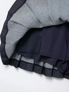 Detail of dark blue denim pleated skirt with built-in safety lining and quality stitching