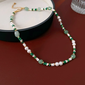 Detailed view of malachite green beads and pearls with gold lobster clasp and chain