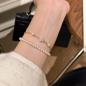 French vintage gold flower bracelet set with white pearls on a lady's wrist