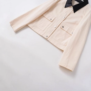 Veste courte en sergé de coton beige avec col noir et boutons métalliques argentés