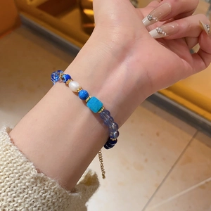 Blue zircon crystal beads bracelet with baroque pearls shown on woman wrist
