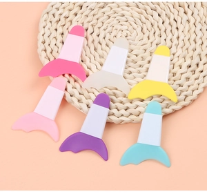 Flat lay of colorful silicone eyeliner guides on a round woven mat for eye makeup