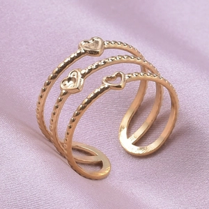 Detail of a gold-plated three-layer open ring featuring heart-shaped charms and twisted band