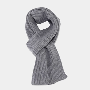 Detail of gray knitted scarf with thick ribbed pattern for winter warmth and soft texture