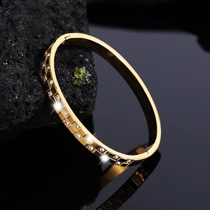 Macro view of gold waffle pattern titanium steel bracelet with sparkling diamond accents