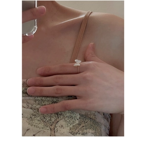 Macro shot of gold butterfly ring with pearl accents on finger for elegant styling