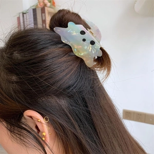 Pince à cheveux fantôme irisée avec finition nacrée sur un chignon élégant