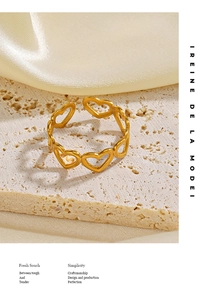 Détail de la bague coeur dorée sur pierre de marbre et fond de soie jaune