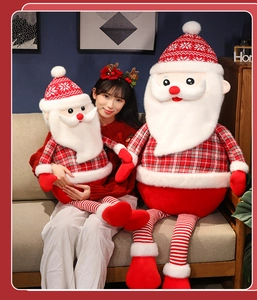 Asian model holding two Santa Claus plush dolls in a cozy Christmas living room scene.