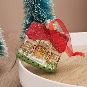 Festive red glitter roof Christmas house ornament with ribbon on a white tray