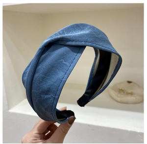 Detail of blue pleated soft fabric texture on wide crisscross headband hair accessory
