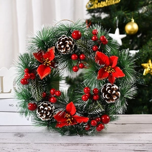 Close-up of Christmas wreath with red berries, pine cones, and needles in home setting