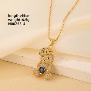 Detail of bear pendant with blue heart gem and white crystals on 45cm gold chain necklace