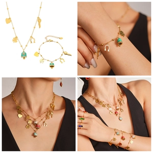 Detail of 18K gold plated necklace and bracelet set with heart and clover charms
