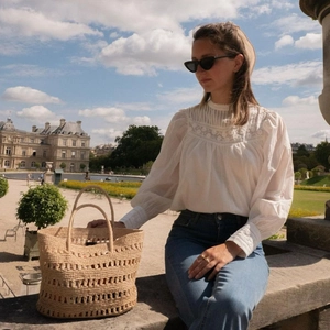 Chic hollow out straw woven handbag carried by a model during an outdoor vacation