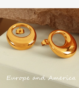 Macro shot of gold hollow oval stud earrings on rock, modern minimalist french design