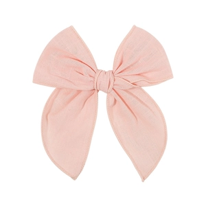 Detail of light pink bow hair clip showing high-quality cotton linen fabric texture