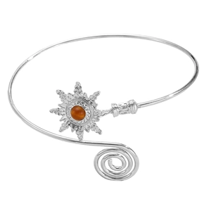 Detail of silver arm cuff featuring starburst sun motif and orange stone inlay