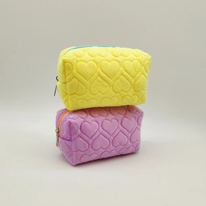 Plush pillow pencil cases in yellow and purple with embossed heart patterns for stationery