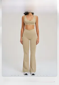 Détail d'un ensemble de yoga beige avec brassière croisée et pantalon évasé à haute élasticité