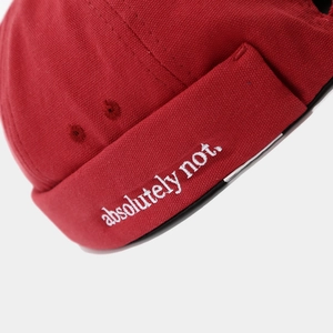Close-up of white 'absolutely not.' embroidery on red canvas docker hat fabric