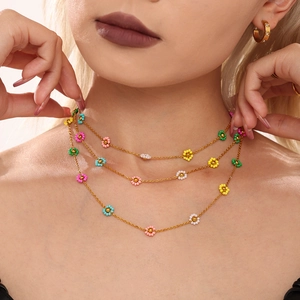 Three-layer beaded necklace featuring colorful floral charms and delicate gold-tone chains